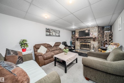 Stone-clad fireplace with mantel, built-in wine rack, and drop ceiling - 10245 160 Street Nw, Edmonton, AB 