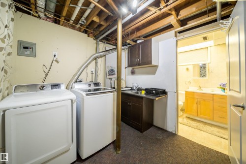 Laundry area featuring a utility sink, dark wood-finish cabinetry, and exposed ceiling joists - 10245 160 Street Nw, Edmonton, AB 