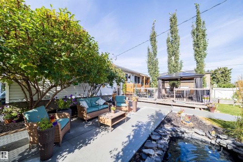 Expansive outdoor living space featuring a wooden deck, covered gazebo, and concrete patio - 10245 160 Street Nw, Edmonton, AB 