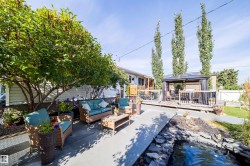 Expansive outdoor living space featuring a wooden deck, covered gazebo, and concrete patio - 