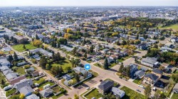 Expansive neighborhood with a mix of residential and commercial properties, featuring mature trees and paved roadways - 