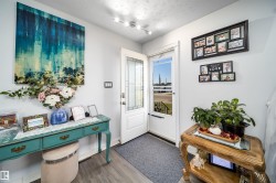 Entryway featuring wood-finish flooring, a white paneled door with decorative glass inserts, and track lighting - 