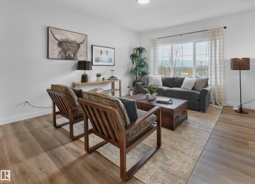 Recessed lighting, wood-finish flooring, and large windows with privacy drapes - 121 Chelles Wynd, St. Albert, AB 