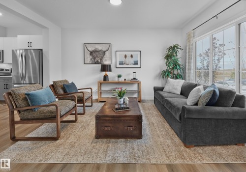Open-concept living space featuring wood-finish flooring, recessed lighting, and a large sliding glass door - 121 Chelles Wynd, St. Albert, AB 
