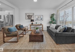 Open-concept living space featuring wood-finish flooring, recessed lighting, and a large sliding glass door - 