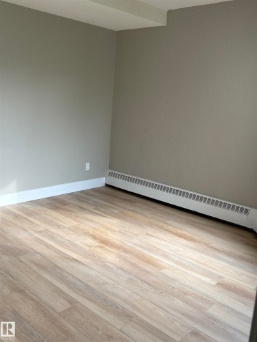 Wood-finish flooring with a neutral wall palette and baseboard heating - #503 11211 85 St Nw, Edmonton, AB 