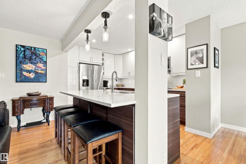 Kitchen featuring a peninsula with a white countertop and dark wood-finish cabinetry - 141 Hearthstone Nw, Edmonton, AB - Indoor Photo Showing Kitchen