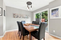 Dining area featuring hardwood flooring, light grey wall paint, and a sliding glass door to an outdoor space - 