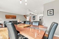 Open-concept living area featuring wood-finish flooring, recessed lighting, and a contemporary light fixture - 
