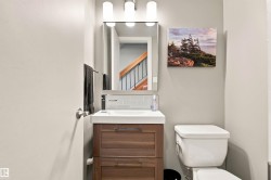 Modern vanity with integrated white sink, wood-finish cabinetry, and contemporary wall-mounted faucet - 