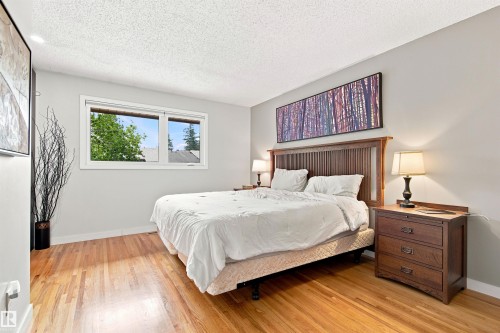 Bedroom featuring wood-finish flooring, light grey walls, and a white popcorn ceiling - 141 Hearthstone Nw, Edmonton, AB - Indoor Photo Showing Bedroom