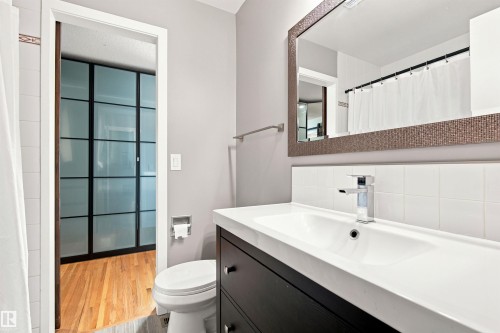 Contemporary bathroom vanity featuring a rectangular integrated sink, chrome faucet, and white tile backsplash - 141 Hearthstone Nw, Edmonton, AB - Indoor Photo Showing Bathroom