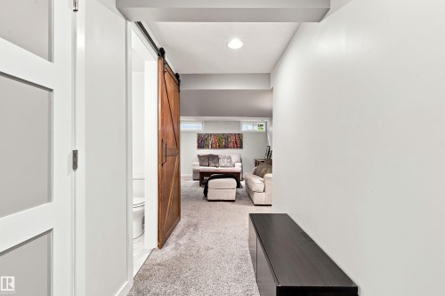 Hallway with light gray walls and a dark wood-finish console table - 141 Hearthstone Nw, Edmonton, AB - Indoor Photo Showing Other Room