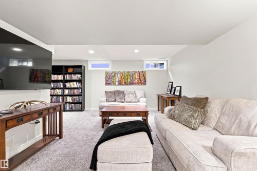 Finished basement living area featuring recessed lighting, light gray wall paint, and gray carpet flooring - 141 Hearthstone Nw, Edmonton, AB - Indoor Photo Showing Basement