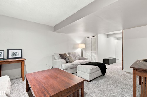 Carpeted room with white walls, featuring a painted ceiling beam and white bifold closet doors - 141 Hearthstone Nw, Edmonton, AB - Indoor