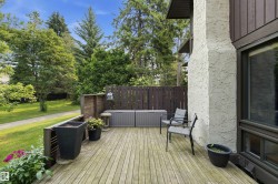 Spacious outdoor decking with a wood plank surface, a privacy fence, and direct access to a landscaped lawn area - 