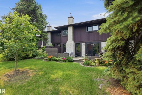 Spacious backyard featuring a manicured lawn, established landscaping, and mature trees - 141 Hearthstone Nw, Edmonton, AB - Outdoor