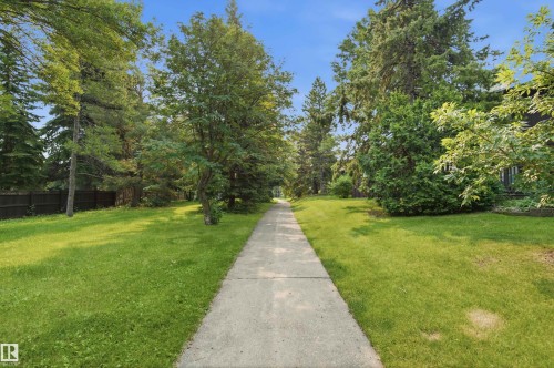 Concrete pathway bordered by expansive lawns and mature trees - 141 Hearthstone Nw, Edmonton, AB - Outdoor