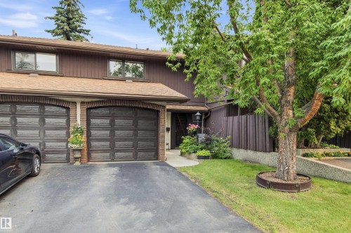 Brown exterior with twin garage doors framed by brick archways - 141 Hearthstone Nw, Edmonton, AB - Outdoor