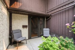 Outdoor patio with a textured stucco wall and vertical wood siding - 