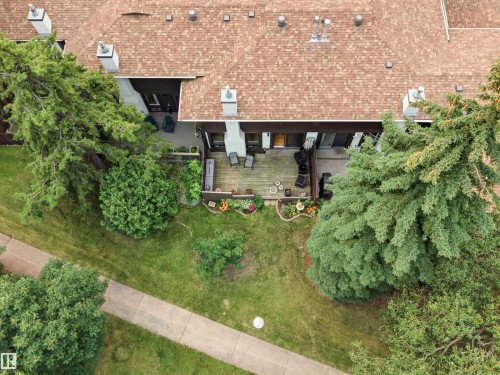 Property featuring a brown shingle roof, chimney stacks, and a wooden deck - 141 Hearthstone Nw, Edmonton, AB - Outdoor