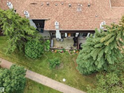 Property featuring a brown shingle roof, chimney stacks, and a wooden deck - 