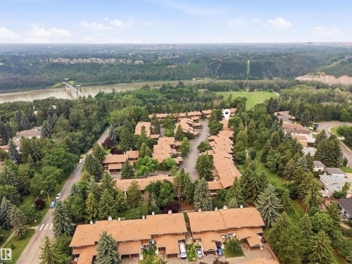 Aerial perspective showcasing a residential community with abundant mature trees and proximity to a significant body of water - 141 Hearthstone Nw, Edmonton, AB - Outdoor With View