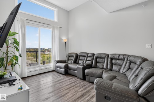 Vaulted ceiling, wood-finish flooring, and a large sliding glass door with transom window - #411 304 Ambleside Link Li Sw, Edmonton, AB 