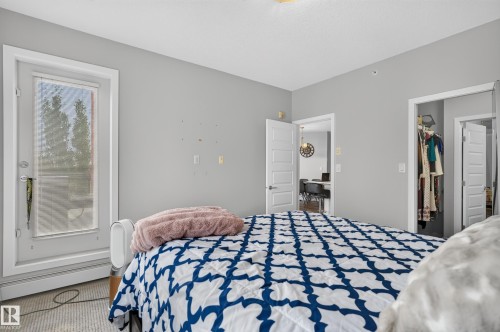 Glass-paneled exterior door, neutral-toned walls, and soft textured carpeting - #411 304 Ambleside Link Li Sw, Edmonton, AB 