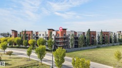 Multi-story building featuring balconies, a neutral color palette, and vertical architectural elements - 