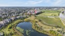 Residential development featuring a natural pond, established green spaces, and a multi-story building - #411 304 Ambleside Link Li Sw, Edmonton, AB 