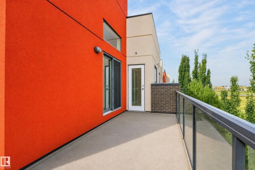 Private balcony featuring a glass railing system and a textured concrete surface - #411 304 Ambleside Link Li Sw, Edmonton, AB 