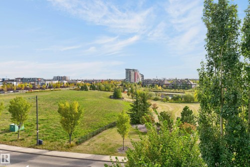 Expansive green space with mature trees and paved pathways - #411 304 Ambleside Link Li Sw, Edmonton, AB 