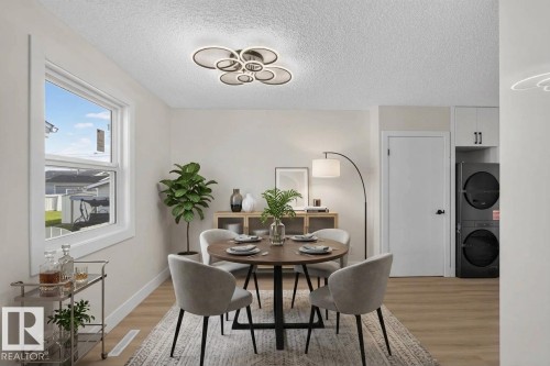 White walls with a textured ceiling, a double-hung window, and wood-finish flooring - 13511 114 Street Nw, Edmonton, AB 