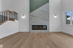 Two-story living area featuring a linear electric fireplace, large format tile surround, and vertical panel accent wall - 