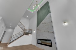 Two-story ceiling with recessed lighting and a decorative chandelier - 