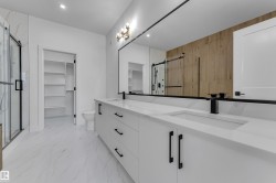 Dual vanity with integrated sinks, white cabinetry, quartz countertops, and matte black fixtures - 