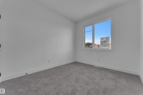 Neutral wall finish, grey carpet flooring, white trim, and a white-framed window - 4212 63 Street, Beaumont, AB 