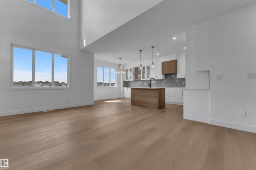 High ceilings, wood-finish flooring, recessed lighting, island with wood-finish base, white cabinetry - 4212 63 Street, Beaumont, AB 