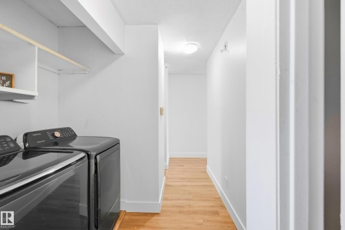 Laundry area with built-in shelving and wood-finish flooring - 258 Surrey Gardens Nw, Edmonton, AB 