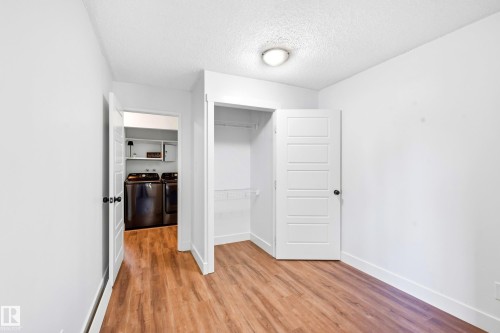 Wood-finish flooring throughout, white interior doors, and a built-in closet with shelving - 258 Surrey Gardens Nw, Edmonton, AB 