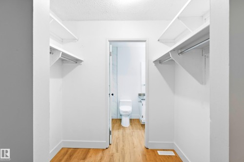 Walk-in closet with dual-sided shelving and hanging rods - 258 Surrey Gardens Nw, Edmonton, AB 