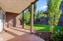 Covered patio with textured ceiling, concrete flooring, and an adjacent grassy area - 258 Surrey Gardens Nw, Edmonton, AB 
