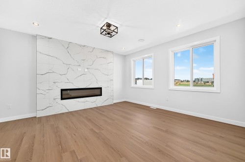 White walls, wood-finish flooring, and two large windows - 9 Tilia Place, Spruce Grove, AB 
