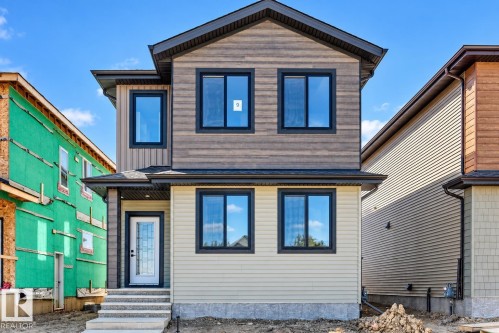 Multifaceted exterior facade with vertical and horizontal siding, dark-framed windows, and a covered entry - 9 Tilia Place, Spruce Grove, AB 