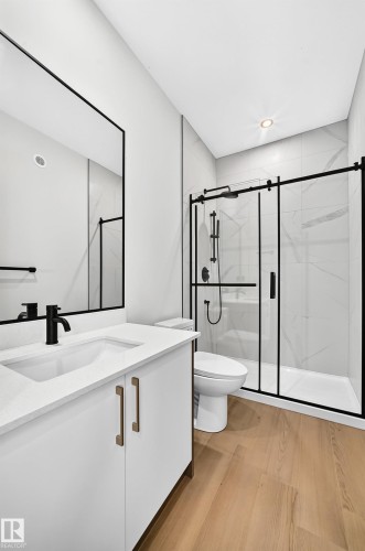 White vanity with bronze hardware, a white countertop, and a black faucet - 9 Tilia Place, Spruce Grove, AB 