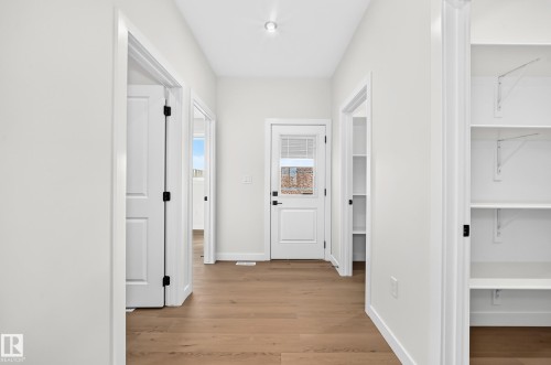 Wood-finish flooring, recessed ceiling light, white panel doors, and built-in shelving - 9 Tilia Place, Spruce Grove, AB 