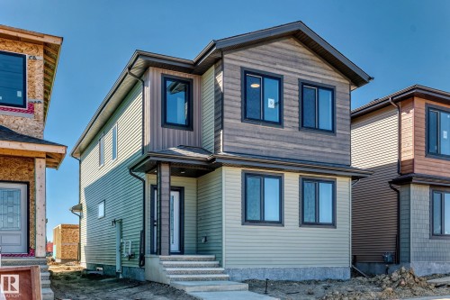 Contemporary exterior featuring multi-toned siding, dark-framed windows, a covered entry, and concrete steps - 9 Tilia Place, Spruce Grove, AB 