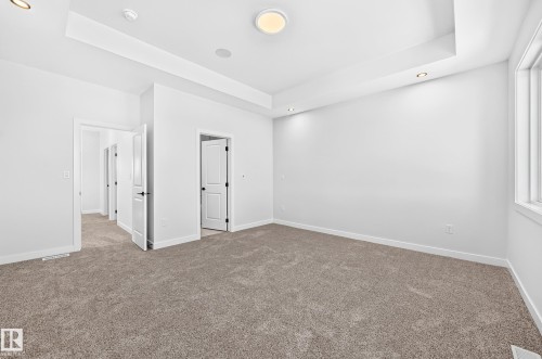 Tray ceiling with recessed lighting, wall-to-wall carpeting, multiple doorways, and a window with white trim - 9 Tilia Place, Spruce Grove, AB 