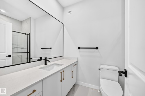 Vanity with an integrated rectangular sink, quartz-finish countertop, and matte black faucet - 9 Tilia Place, Spruce Grove, AB 